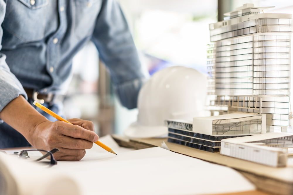 Person zeichnet einen Aufbau einer Konstruktion